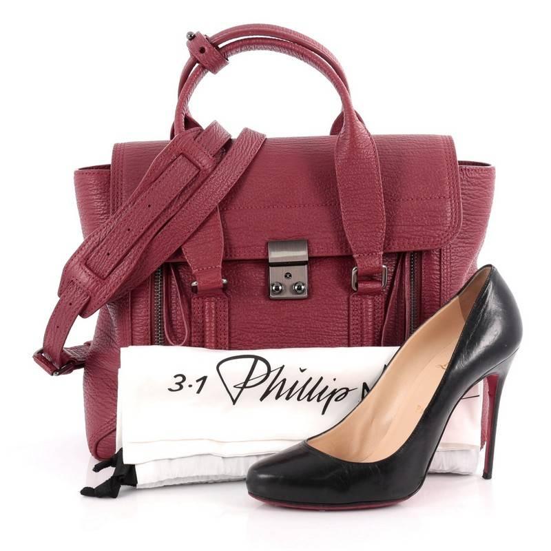This authentic 3.1 Phillip Lim Pashli Satchel Leather Medium is a practical bag with a stylish edge made for on-the-go moments. Crafted from crimson red leather, this chic satchel features dual top handles, expandable zip sides, top flap push-lock