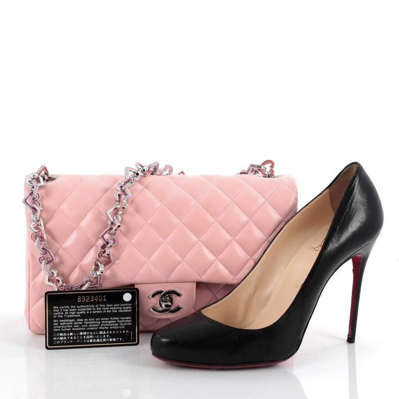 This authentic Chanel Vintage Valentine Hearts Flap Bag Quilted Lambskin Medium is a rare and highly sought after bag from the brands 2004 Collection. Crafted from pink quilted lambskin leather, this stylish bag features a playful heart shape charms