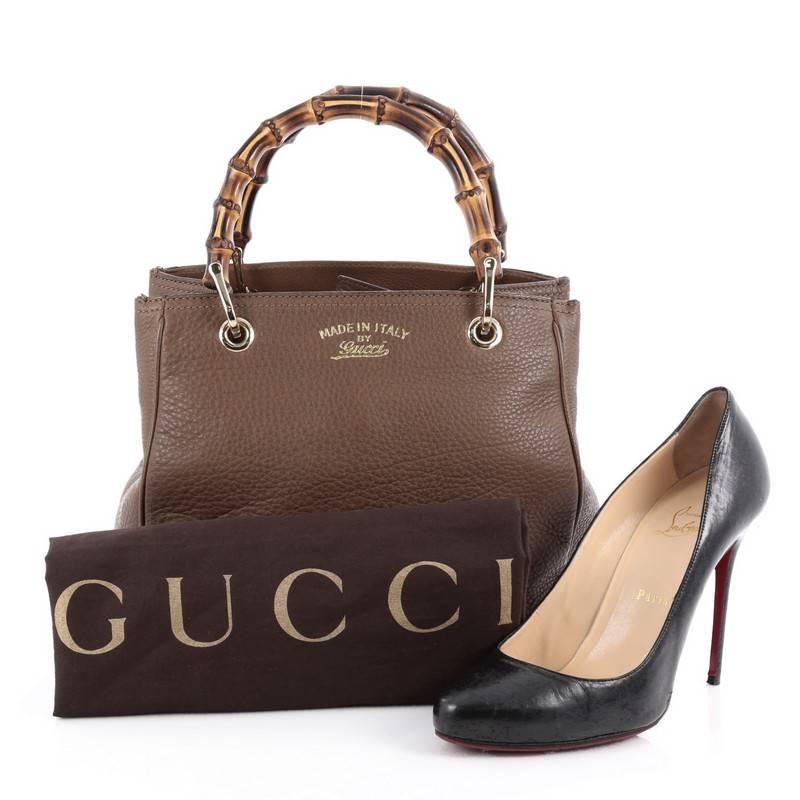 This authentic Gucci Bamboo Shopper Tote Leather Small is a classic must-have. Crafted in brown leather, this simple yet stylish tote features Gucci's signature sturdy bamboo handles, protective base studs, stamped logo at the front and bamboo and
