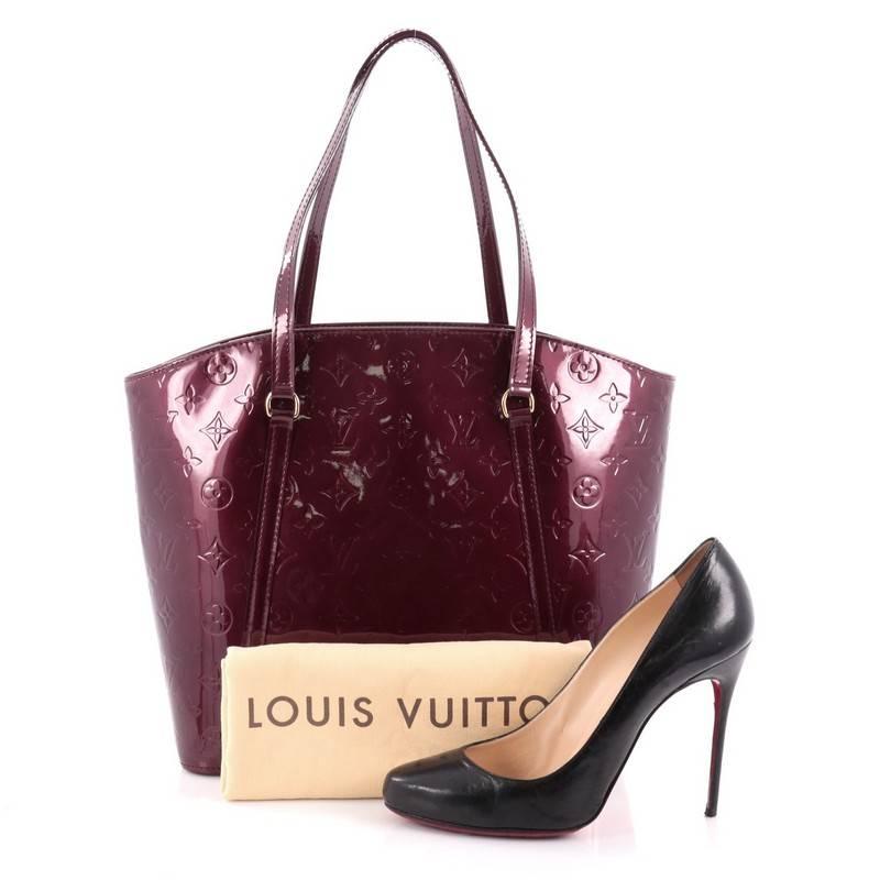 This authentic Louis Vuitton Avalon Handbag Monogram Vernis GM is a fresh and elegant spin on a classic style that is perfect for all seasons. Crafted from Louis Vuitton's rouge fauviste monogram vernis leather, this fan-shaped tote features dual