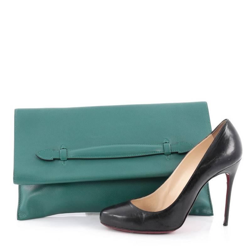 This authentic Hermes Pliplat Clutch Evercolor is a stunning piece that will always be a timeless classic. Crafted from malachite green leather, this clutch features fold-over flap top, and small slid handle. It opens to a green leather-lined