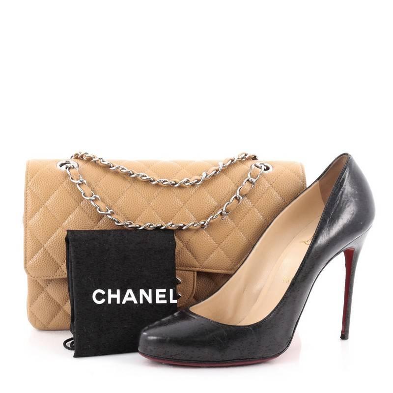This authentic Chanel Vintage Classic Double Flap Bag Quilted Caviar Medium exudes a classic yet easy style made for the modern woman. Crafted from light brown caviar leather, this elegant flap features woven-in leather silver chain straps, Chanel's