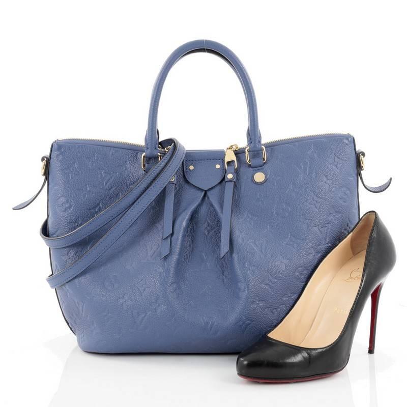 This authentic Louis Vuitton Mazarine Handbag Monogram Empreinte Leather MM is from the brand's 2016 Cruise Collection that is both stylish and feminine. Crafted from blue monogram empreinte leather, this gorgeous bag features dual-rolled leather