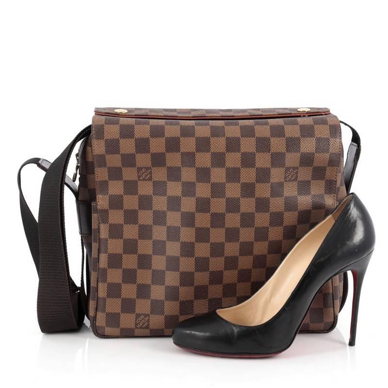 This authentic Louis Vuitton Naviglio Handbag Damier is perfect for style-conscious man or woman on the go. Crafted from brown ebene coated canvas, this elegant bag features wide canvas adjustable strap, large dual flap design, and gold-tone