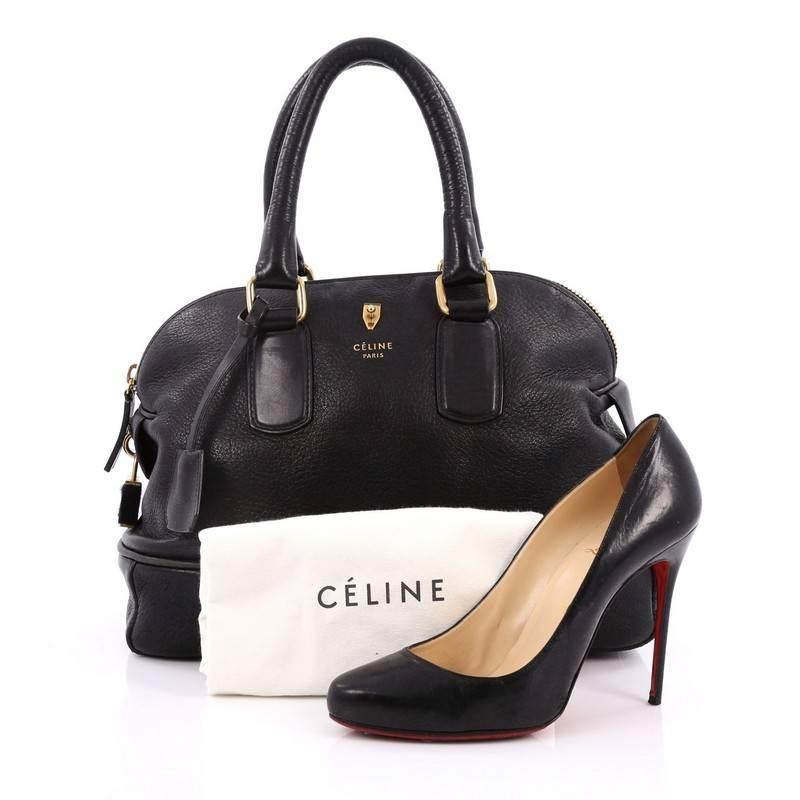 This authentic Celine Bowling Bag Leather Medium is an understated, stylized bowling bag made for the modern woman. Constructed from black leather, this chic bowler bag features dual-rolled leather handles, logo imprint and with pin detail at center