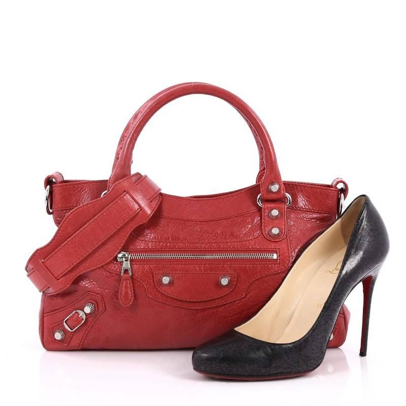 This authentic Balenciaga First Giant Studs Handbag Leather is true to the brand's easy, luxe aesthetic. Constructed in red leather, this popular bag features braided woven handle straps, front zip pocket and iconic Balenciaga silver giant hardware
