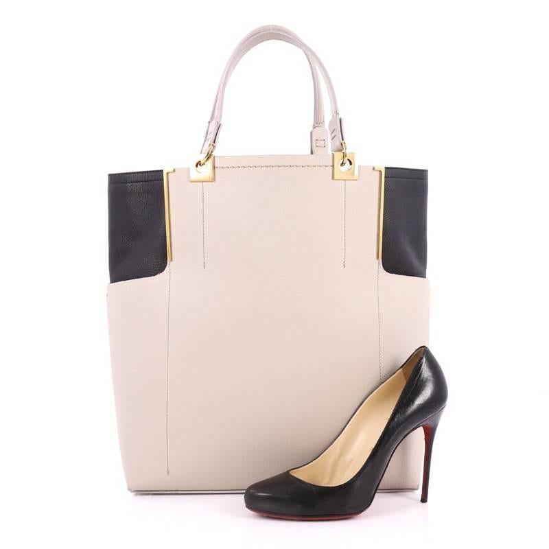 This authentic Lanvin Partition Tote Leather is the perfect size bag for glossy magazines or a document folder. Crafted from light taupe and black leather, this bag features dual top leather handles, protective base studs, and gold-tone hardware