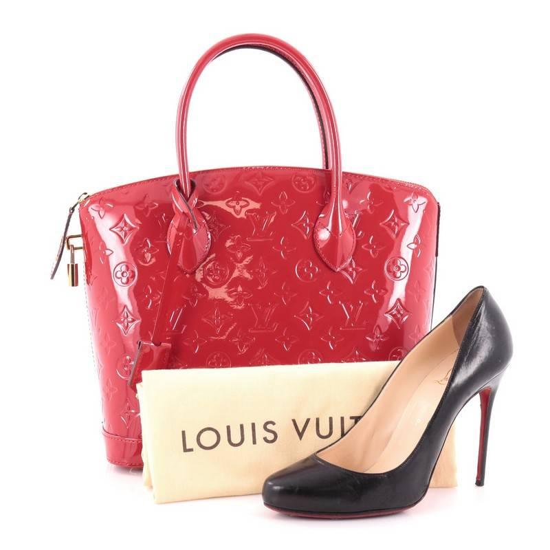 This authentic Louis Vuitton Lockit Handbag Monogram Vernis PM mixes the brand's penchant for timeless designs with modern flair. Crafted from red monogram vernis, this chic bag features dual toron top handles, protective base studs and gold-tone