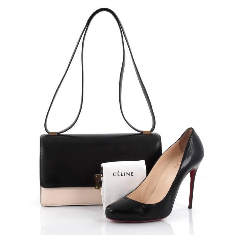 This authentic Celine Case Flap Bag Leather Medium presented in the brand's 2012-2013 Collection is a statement piece that stylishly complements all outfits. Crafted in black and bone leather, this minimalist flap features flat leather shoulder