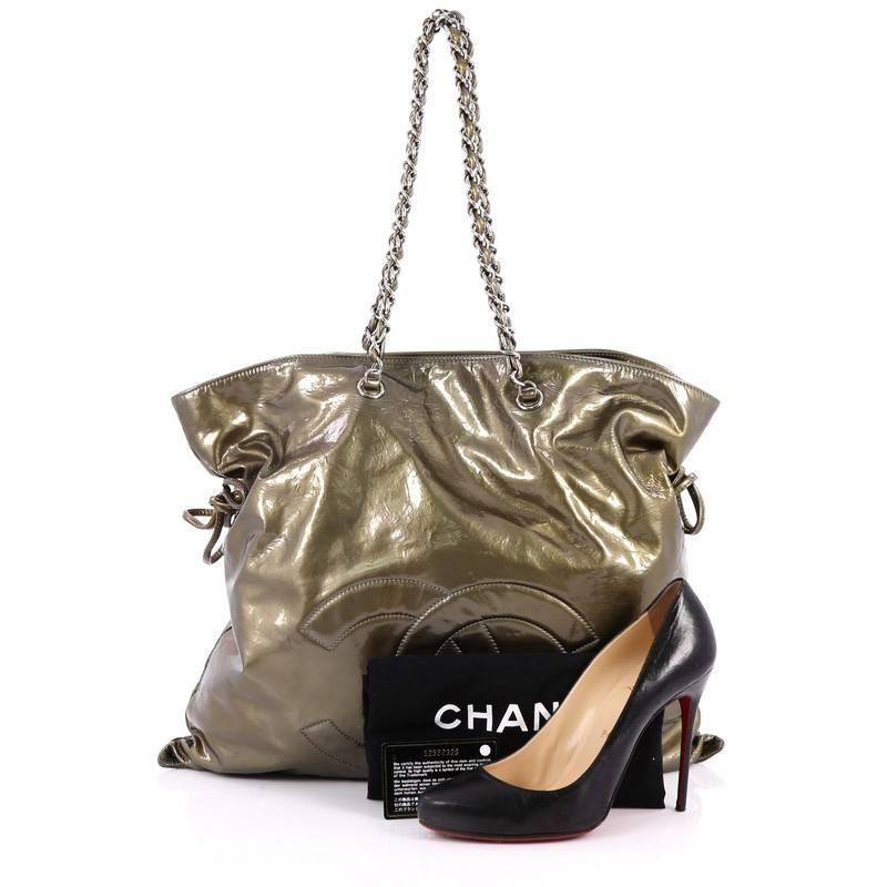 This authentic Chanel Bon Bon Tote Patent Large is a modern design with subtle edge made for everyday use. Crafted from green patent leather, this no-fuss, stylish tote features an oversized CC stitched logo, woven-in leather chain straps, side