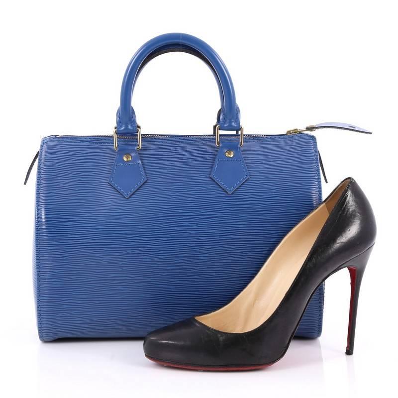 This authentic Louis Vuitton Speedy Handbag Epi Leather 25 is a timeless favorite of many. Crafted in blue epi leather, this bag features dual-rolled handles, subtle stamped LV logo, exterior side slip pocket and gold-tone hardware accents. Its top