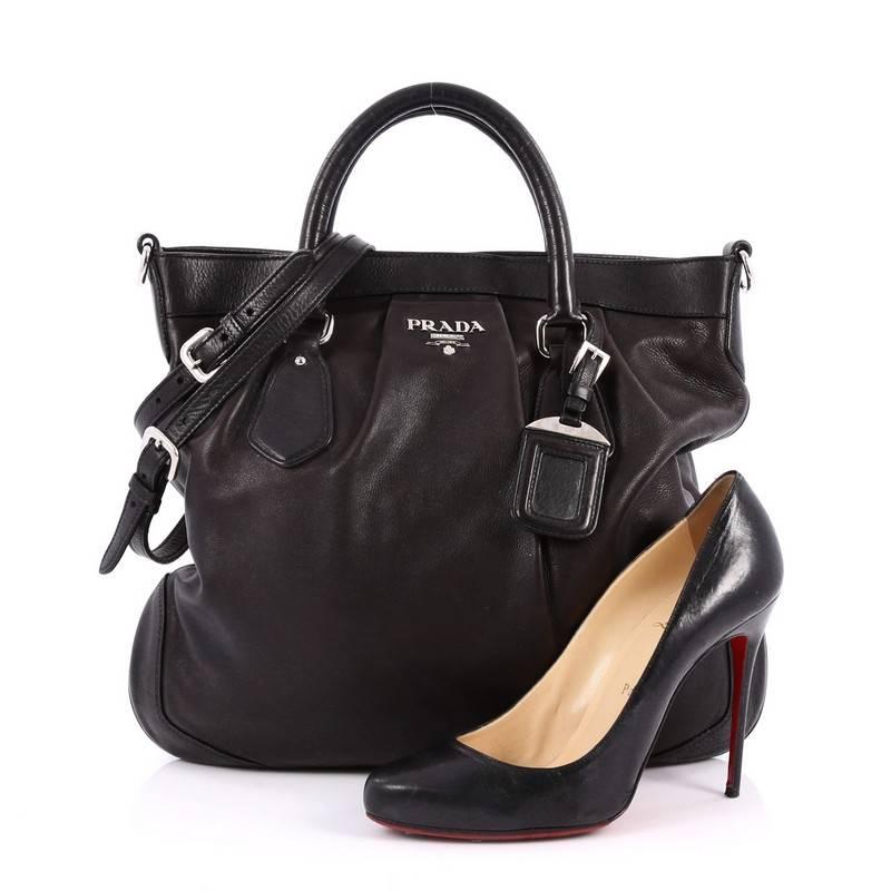This authentic Prada Convertible Belted Satchel Vitello Soft Large is a perfect companion for daily excursions. Crafted from black vitello soft leather, this satchel features dual-rolled leather handles, Prada Milano logo, and silver-tone hardware