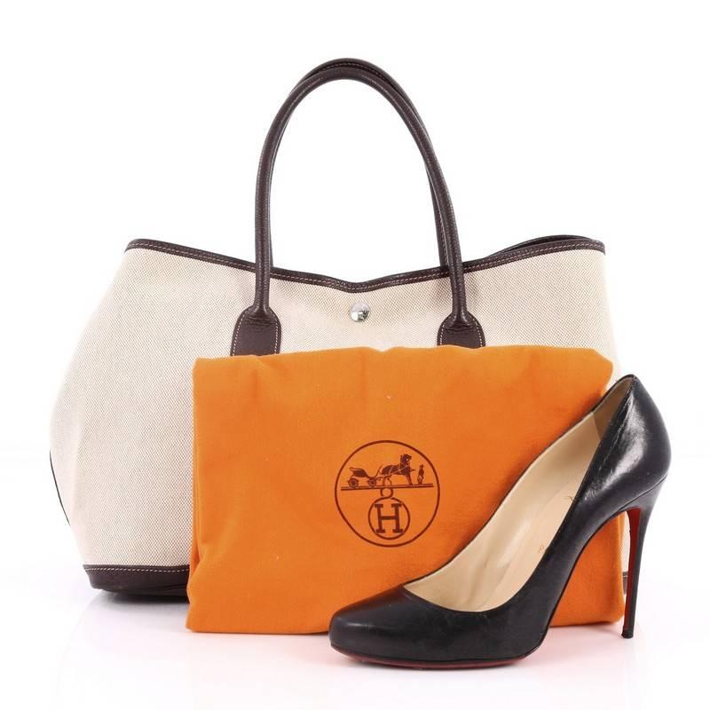 This authentic Hermes Garden Party Tote Toile and Leather 36 is an elegant and simple tote made for all seasons. Crafted from natural toile with brown buffalo leather trims, this chic everyday tote features dual-rolled leather top handles, stand-out