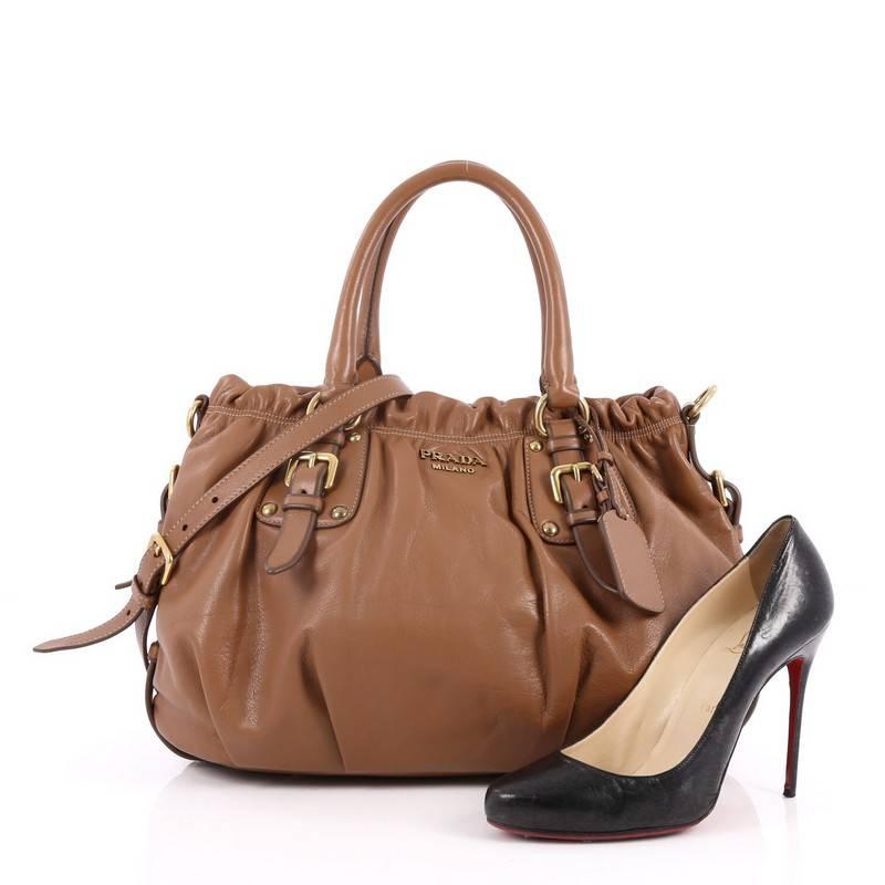 This authentic Prada Convertible Belted Satchel Cervo Leather Medium is a beautifully and intricately crafted bag perfect for everyday use. Constructed in brown cervo antik leather, this bag features dual-rolled handles, belted sides, trademark