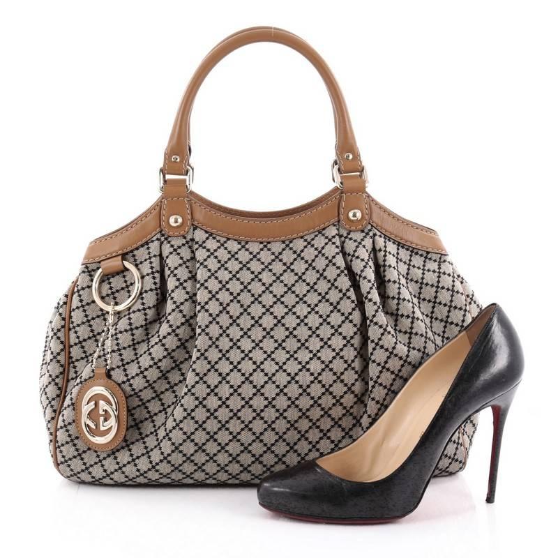 This authentic Gucci Sukey Tote Diamante Canvas Medium is sophisticated in design and modernly chic perfect for casual excursions. Crafted in brown and black diamante coated canvas with brown leather trims, this soft bag features dual-rolled