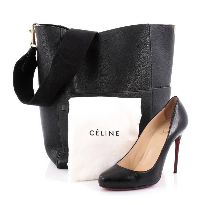 This authentic Celine Sangle Seau Handbag Calfskin Large presented in the brand's Fall 2015 Collection balances a simple yet luxurious style perfect for an on-the-go woman. Crafted from black calfskin leather, this minimalist bucket bag features a