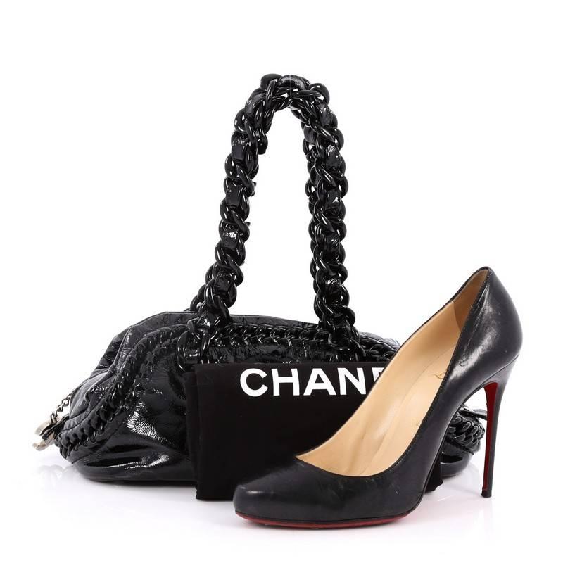 This authentic Chanel Resin Luxe Ligne Bowler Bag Patent Medium showcases an edgy appeal and playful sporty style perfect for avid Chanel lovers. Crafted from black patent leather, this bowler-shaped bag features large resin chain link top handles