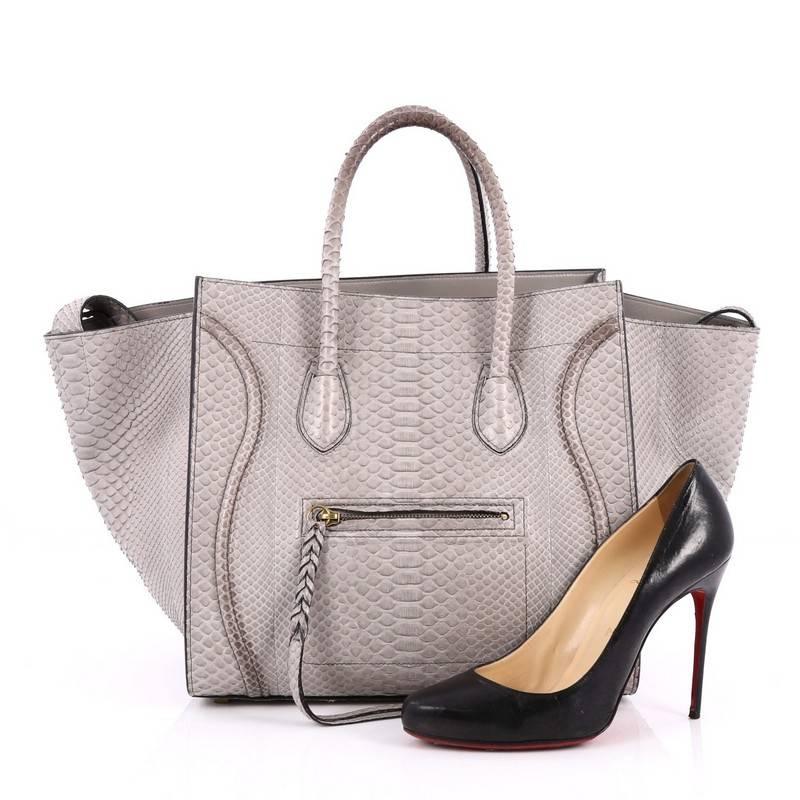 This authentic Celine Phantom Handbag Python Medium by Phoebe Philo mixes classic minimalist Celine style with casual, luxe detailing. Crafted from genuine grey python skin, this ultra-chic bag features exterior front zip pocket with braided zipper