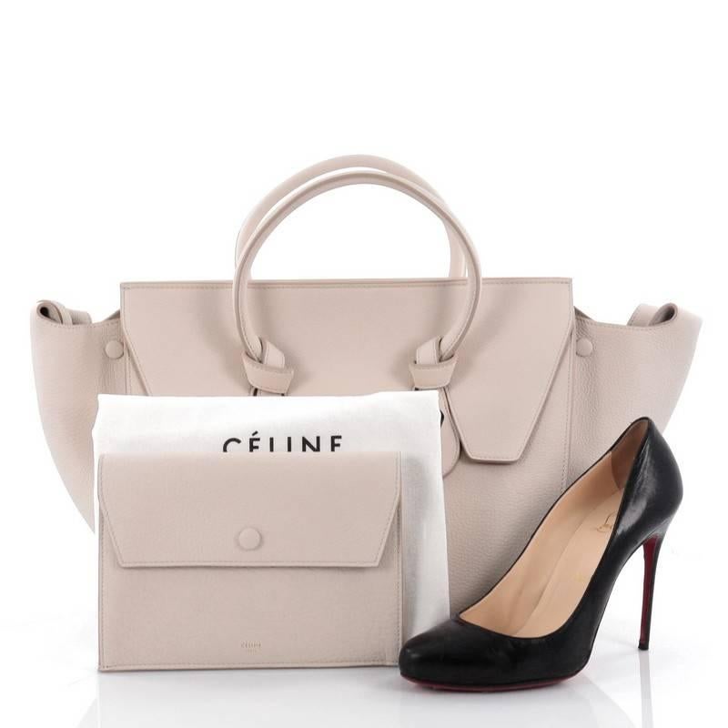 This authentic Celine Tie Knot Tote Grainy Leather Medium is an absolute must-have for serious fashionistas. Crafted from light grey grainy leather, this boxy, chic tote features dual-rolled leather handles with signature knot accents, expandable