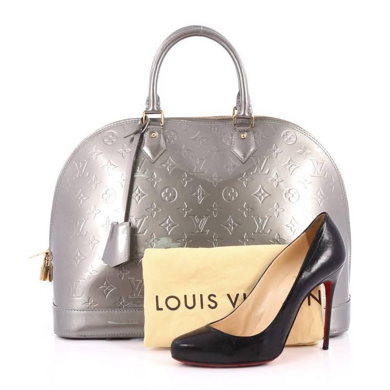 This authentic Louis Vuitton Alma Handbag Monogram Vernis GM is a fresh and elegant spin on a classic style that is perfect for all seasons. Crafted from Louis Vuitton's silver metallic monogram vernis leather, this dome-shaped satchel features