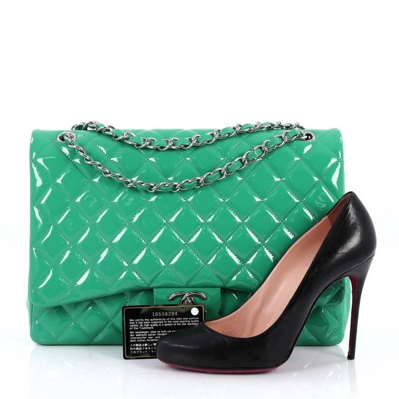 This authentic Chanel Classic Double Flap Bag Quilted Patent Maxi exudes a classic yet easy style made for the modern woman. Crafted from green patent leather, this elegant flap features Chanel's signature diamond quilted design, woven-in leather