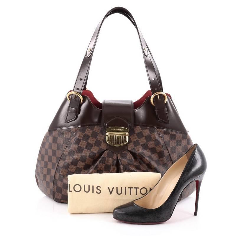 This authentic Louis Vuitton Sistina Handbag Damier GM is perfect for an everyday look for the modern woman. Crafted in the brand's iconic damier ebene coated canvas, this stylish yet feminine tote features subtle center pleating, smooth brown