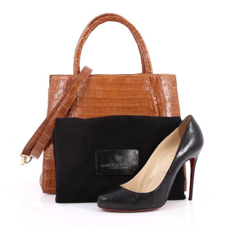 This authentic Nancy Gonzalez Convertible Tote Pleated Crocodile Large is the perfect combination of luxurious style and a polished aesthetic made for the modern woman. Crafted from genuine brown crocodile skin with pleated detailing, this