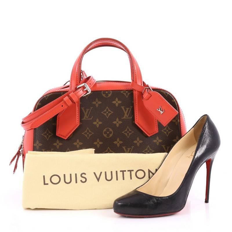 This authentic Louis Vuitton Dora Handbag Monogram Canvas and Calf Leather PM presented in the brand's Pre-Fall 2015 Collection is inspired by Gaston Vuitton's iconic squire travel bag. Crafted from brown monogram printed canvas and rouge red calf
