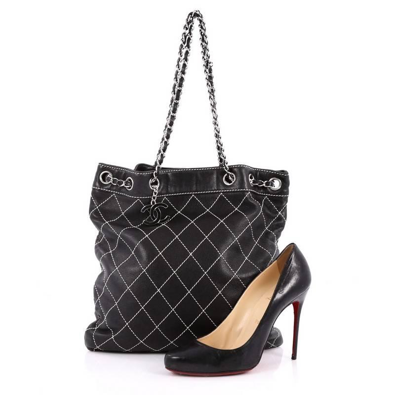 This authentic Chanel Surpique Drawstring Bucket Bag Quilted Lambskin Large is sure to brighten up someone's day. Crafted from black lambskin leather, this bucket bag features Chanel's signature diamond quilted leather in white contrast stitching,