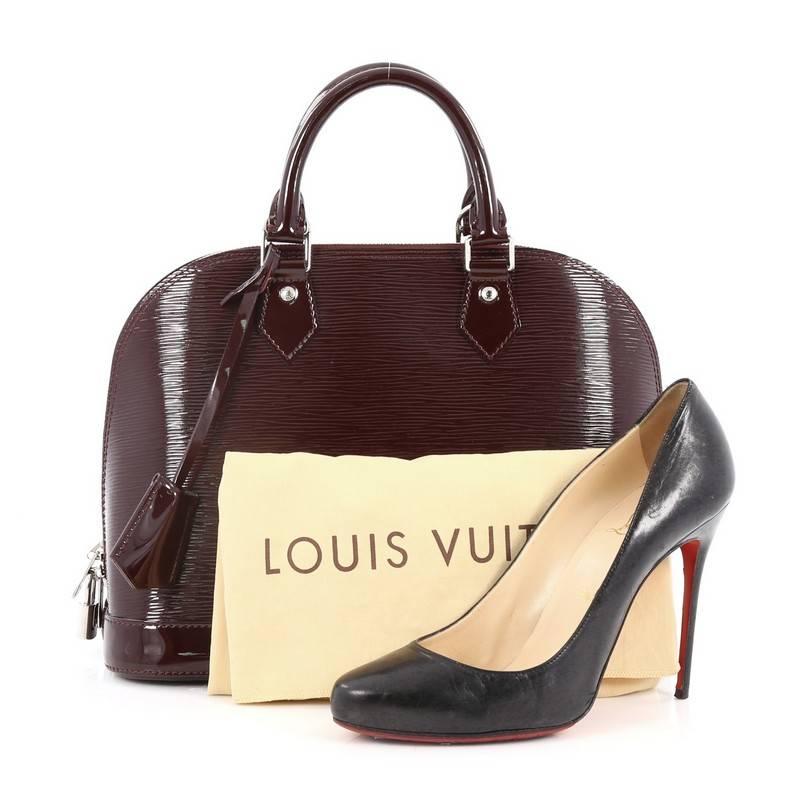 This authentic Louis Vuitton Alma Handbag Electric Epi Leather PM is elegant and as classic as they come. Constructed with Louis Vuitton's signature sturdy wine electric epi leather in a dome-like silhouette, this iconic bag features dual rolled