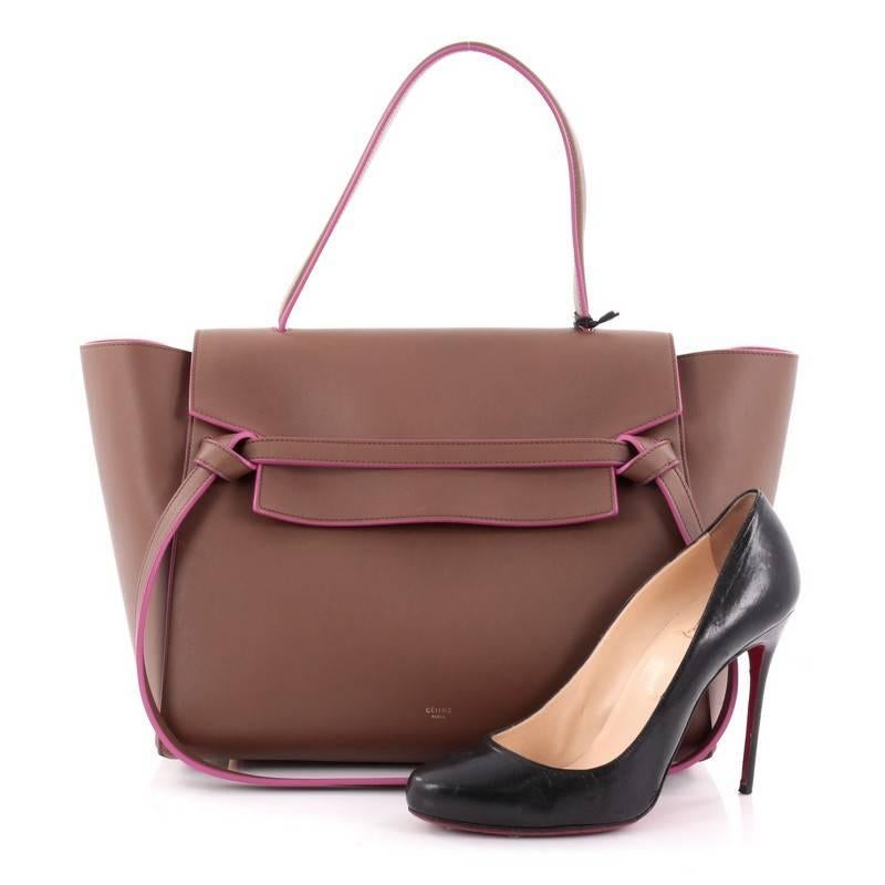 This authentic Celine Belt Bag Calfskin Small is sure to make a statement. Crafted from brown calfskin leather, this bold and sleek accessory features expanded wings, looped single top handle, top flap slide closure, stamped Celine logo, zipper