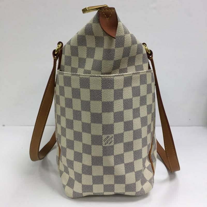 This authentic Louis Vuitton Totally Handbag Damier MM is a chic and practical bag for everyday occasions. Crafted from Louis Vuitton's iconic damier azur coated canvas, this simple city tote features tall cowhide leather handles and trims, two