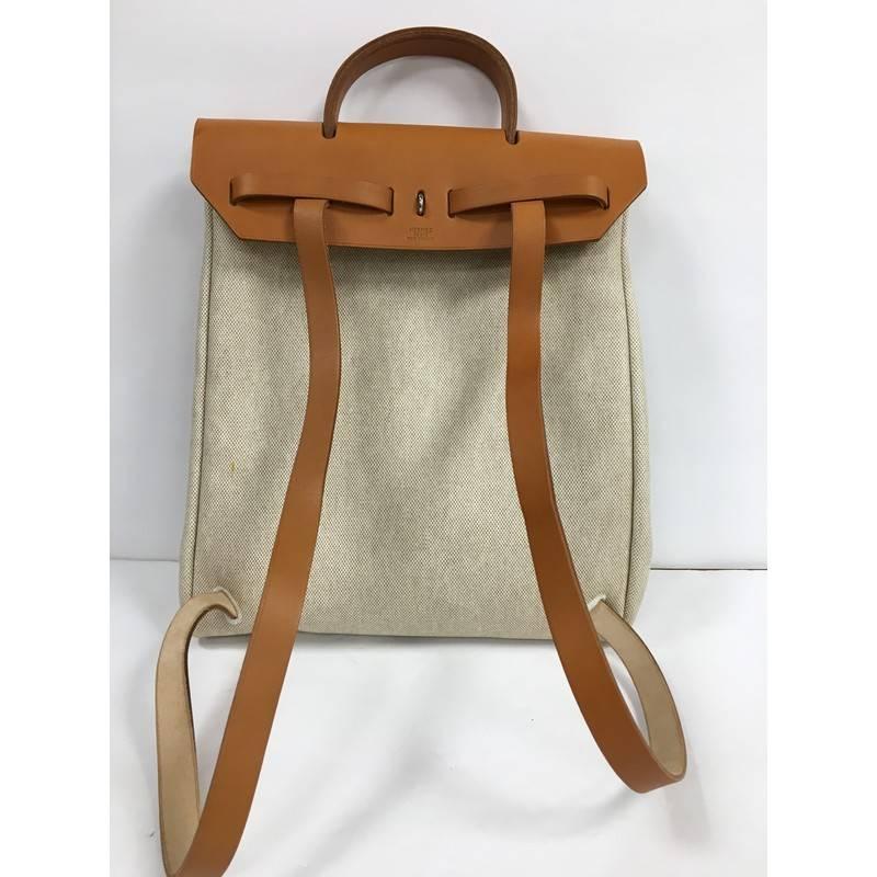 This authentic Hermes Herbag Backpack Toile is a fabulously functional Hermes set with two stylishly classic handbags fitting any mood. Constructed from beige canvas, this functional interchangeable backpack showcases a brown top leather handle and