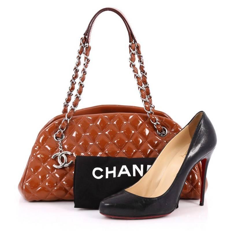 This authentic Chanel Just Mademoiselle Handbag Quilted Patent Medium showcases a sleek style that complements any look. Crafted from dark orange patent leather in Chanel's iconic diamond quilt pattern, this bag features woven-in leather chain