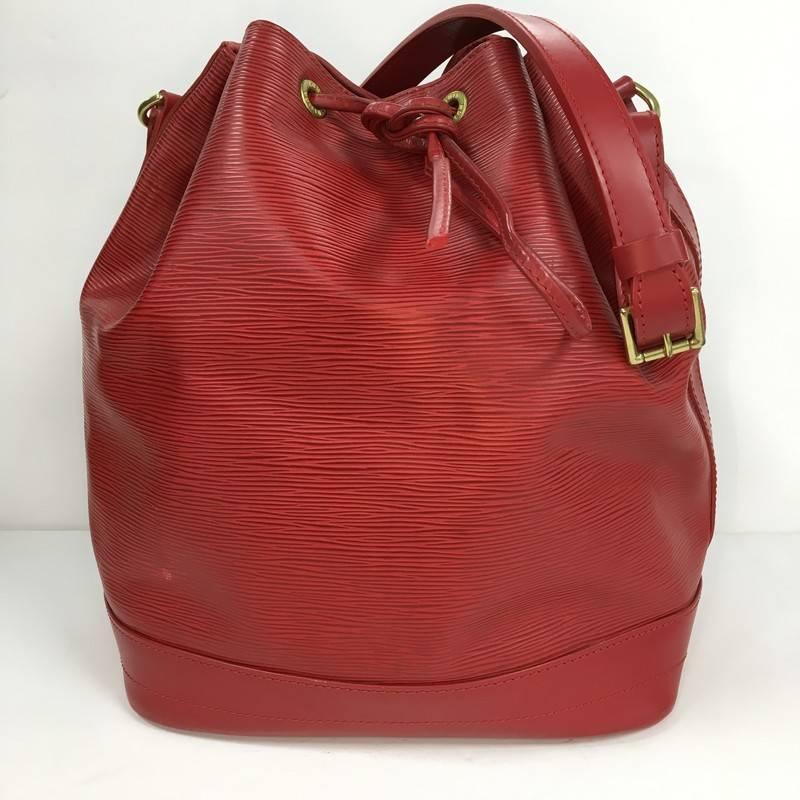 This authentic Louis Vuitton Noe Handbag Epi Leather Large is a chic and iconic bucket bag made for the modern fashionista. Crafted from rubis red epi leather, this bucket bag features adjustable shoulder straps, subtle LV logo, leather drawstring