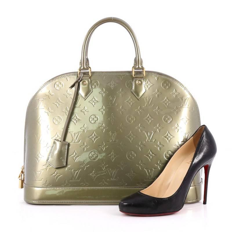This authentic Louis Vuitton Alma Handbag Monogram Vernis GM is a fresh and elegant spin on a classic style that is perfect for all seasons. Crafted from Louis Vuitton's green monogram vernis leather, this dome-shaped satchel features dual-rolled