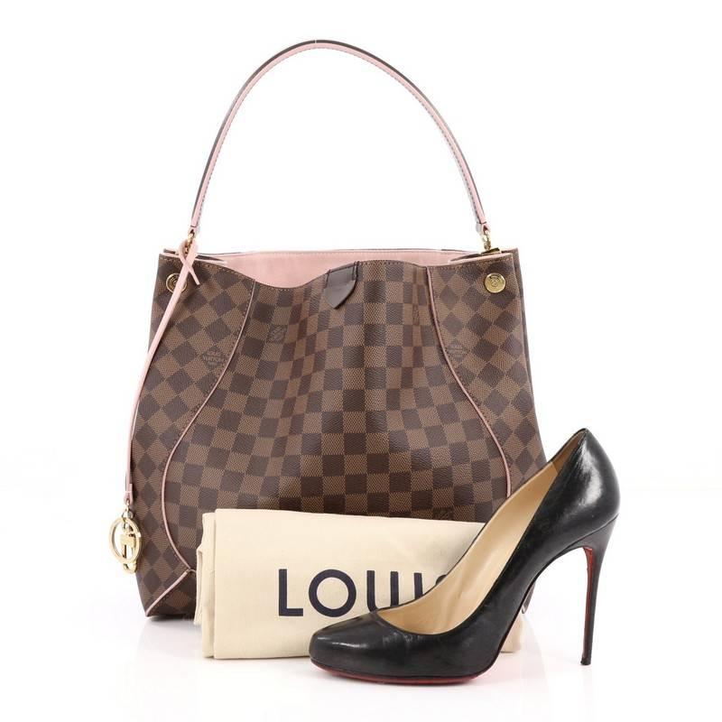 This authentic Louis Vuitton Caissa Hobo Damier mixes casual elegance with understated finesse made for everyday use. Crafted from damier ebene coated canvas, this luxurious hobo features a looping shoulder strap with polished gold anchors, light