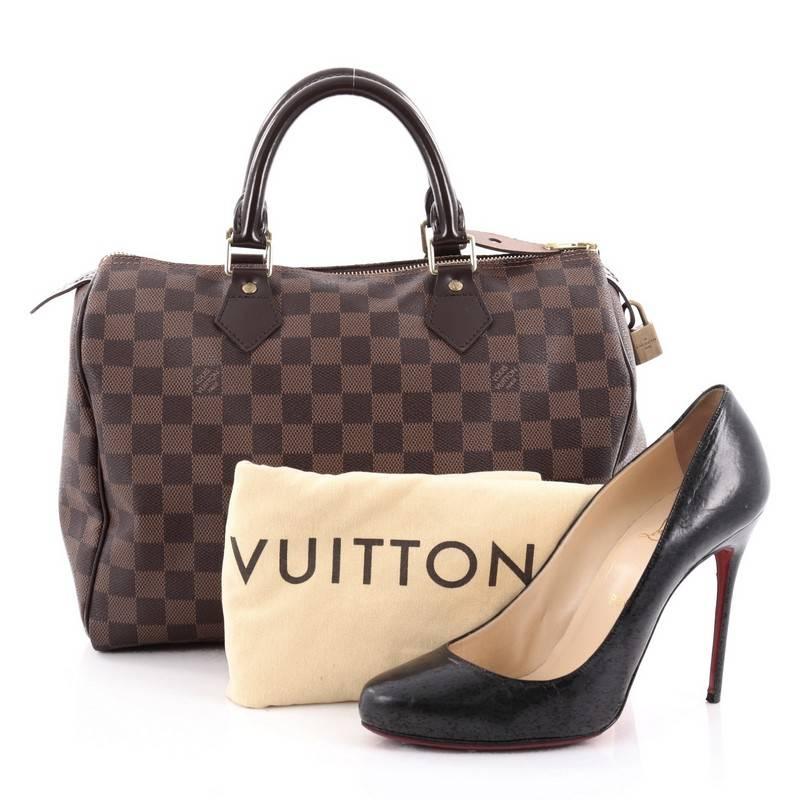 This authentic Louis Vuitton Speedy Handbag Damier 30 is a timeless favorite of many. Constructed from Louis Vuitton's signature damier ebene coated canvas, this iconic Speedy features dual-rolled handles, brown leather trims and gold-tone hardware