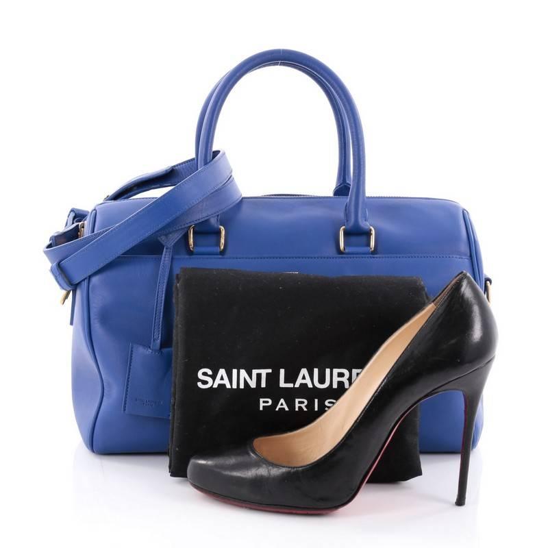 This authentic Saint Laurent Classic Duffle Bag Leather 6 is a modern and elegant duffle bag to travel in style with. Crafted in electric blue leather, this alluring bag features dual-rolled leather handles, detachable strap, stamped Saint Laurent