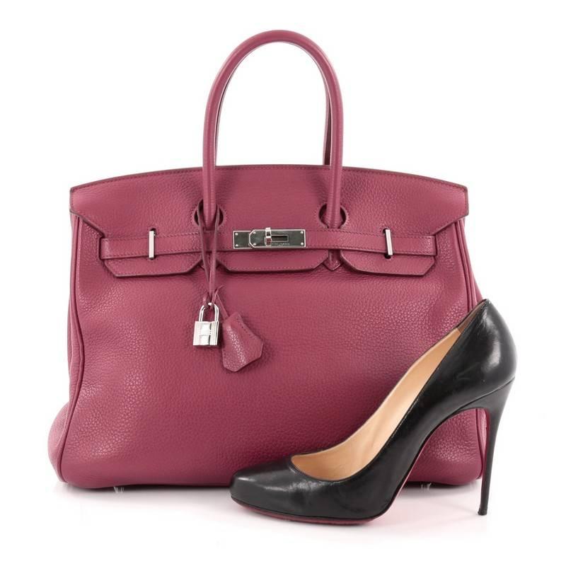 This authentic Hermes Birkin Handbag Rubis Clemence with Palladium Hardware 35 is synonymous to traditional Hermes luxury. Crafted with sturdy, scratch-resistant Rubis clemence leather, this eye-catching luxurious tote is accented with polished