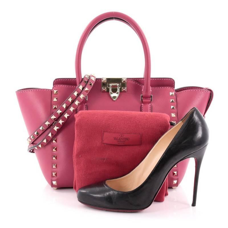 This authentic Valentino Rockstud Tote Rigid Leather Small is the perfect daily bag for an on-the-go fashionista. Crafted in sleek pink rigid leather, this stylish, structured tote features tall dual-rolled handles, gold-tone pyramid stud trim