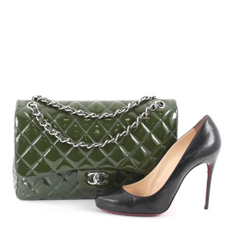 This authentic Chanel Classic Double Flap Bag Quilted Patent Jumbo exudes a classic yet easy style made for the modern woman. Crafted from green patent leather, this elegant flap features Chanel's signature diamond quilted design, woven-in leather