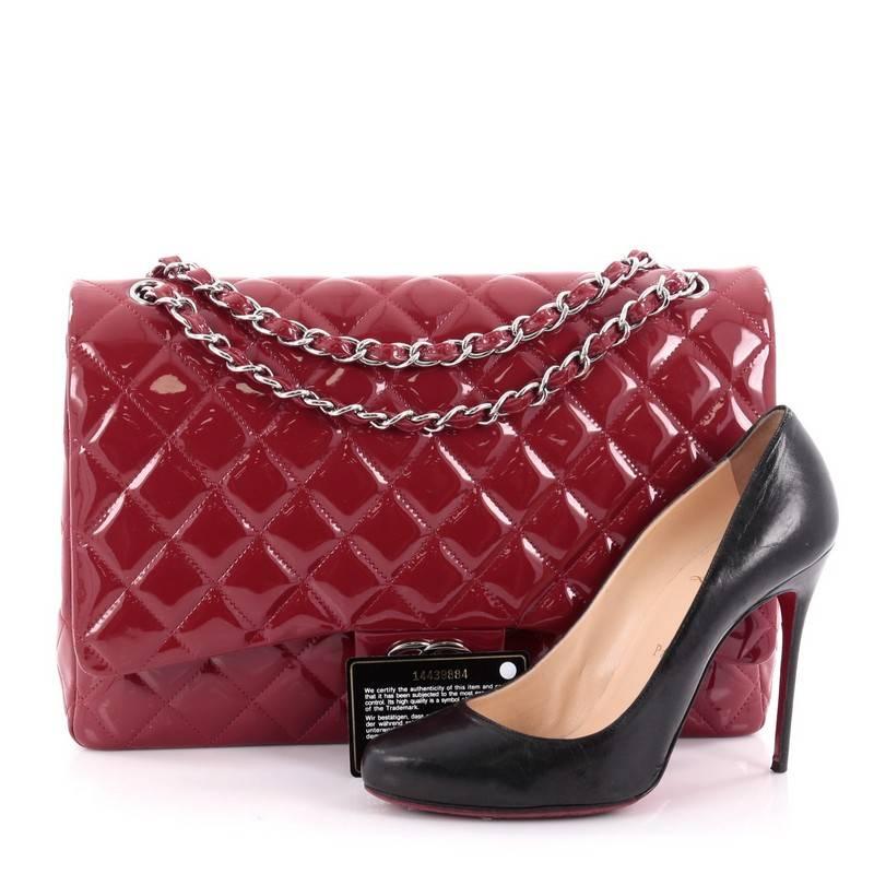 This authentic Chanel Classic Double Flap Bag Quilted Patent Maxi exudes a classic yet easy style made for the modern woman. Crafted from dark red patent leather, this elegant flap features Chanel's signature diamond quilted design, woven-in leather