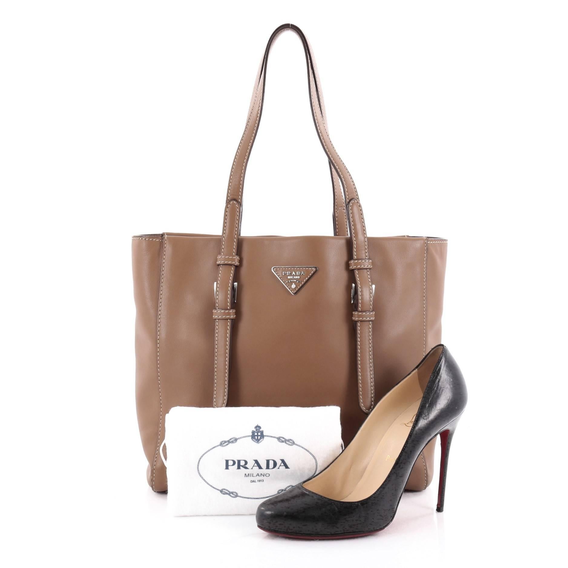 This authentic Prada Covered Strap Open Tote City Calfskin Medium is elegant in its simplicity and structure, a mark of Prada's fine craftsmanship. Crafted from sturdy brown calfskin leather, this tote features dual-flat leather handles with