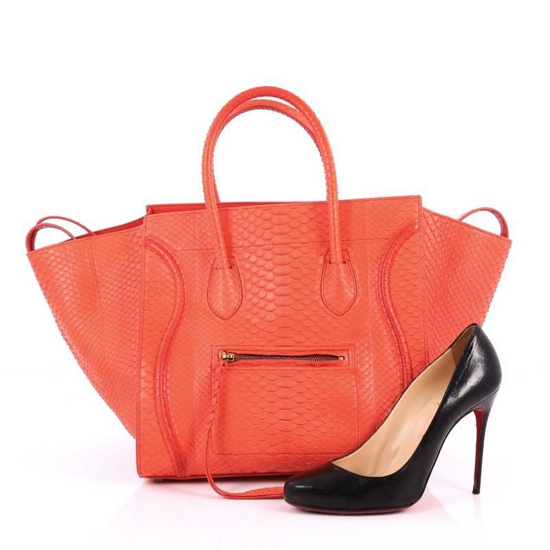 This authentic Celine Phantom Handbag Python Medium by Phoebe Philo mixes classic minimalist Celine style with casual, luxe detailing. Crafted from genuine coral red python skin, this ultra-chic bag features exterior front zip pocket with braided