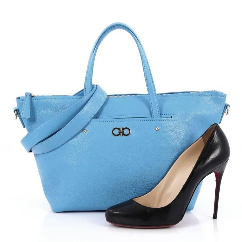 This authentic Salvatore Ferragamo Mika Convertible Tote Leather Small is perfect for your spring and summer escapades. Crafted in bright blue leather, this simple tote features signature Gancini gold hardware at its center, dual-top flat handles,