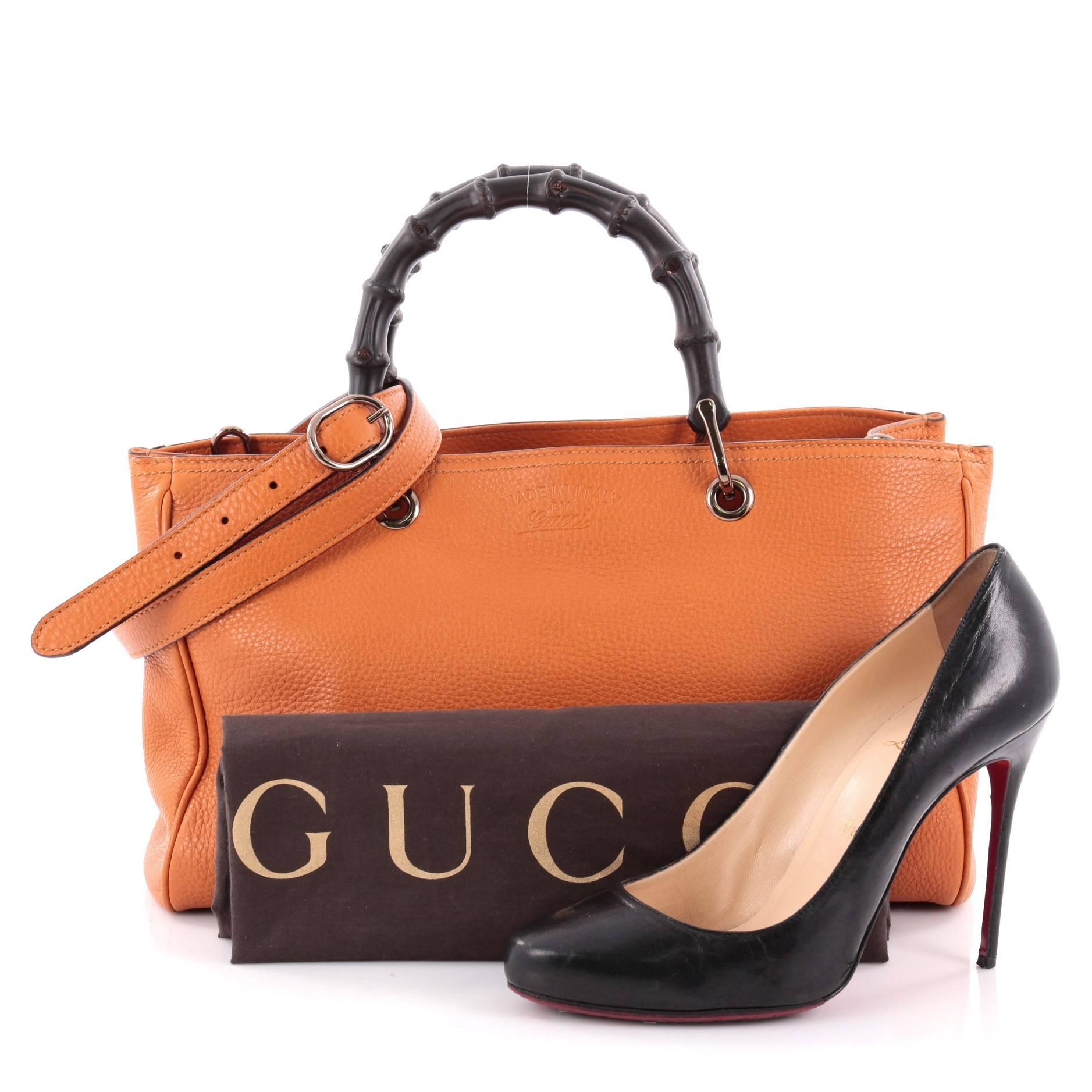 This authentic Gucci Bamboo Shopper Tote Leather Medium is a classic must-have. Crafted from orange leather, this simple yet stylish tote features Gucci's signature sturdy bamboo handles, protective base studs, stamped logo at the front, and rose