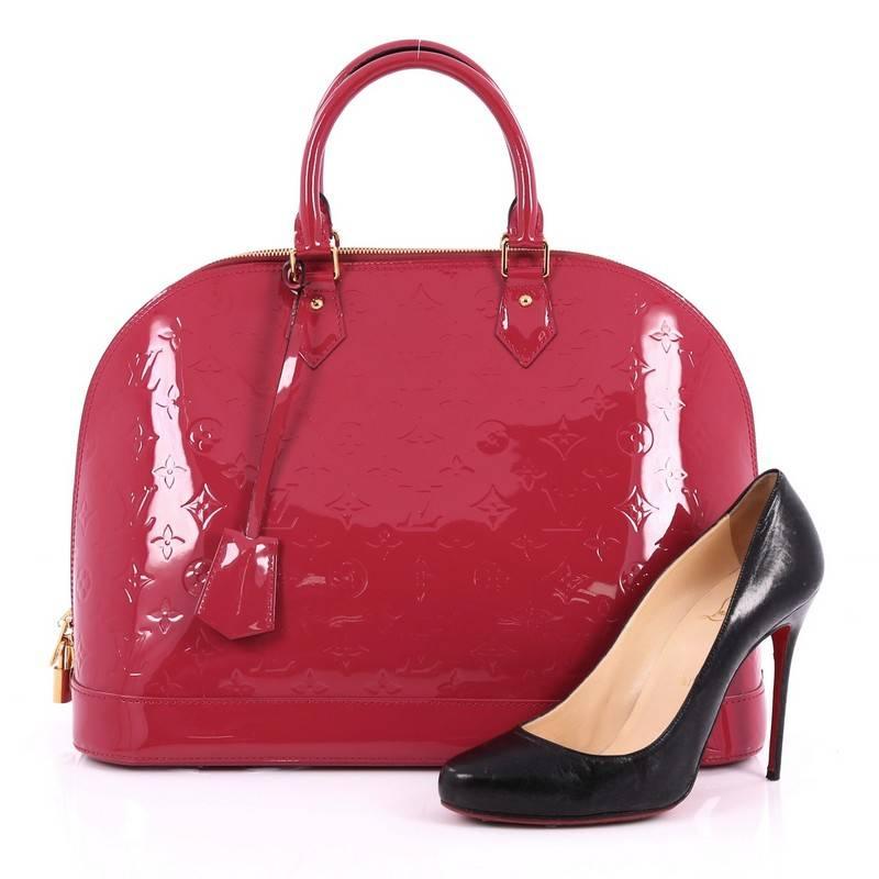 This authentic Louis Vuitton Alma Handbag Monogram Vernis MM is a fresh and elegant spin on a classic style that is perfect for summer. Crafted from Louis Vuitton's glossy dark pink monogram vernis patent leather, this bag features dual-rolled