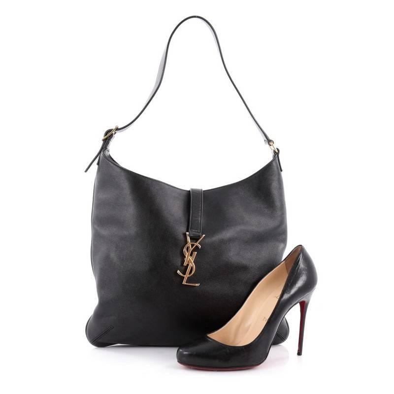 This authentic Saint Laurent Classic Monogram Hobo Leather Medium is classic and sophisticated bag perfect for everyday use. Crafted in black leather, this hobo features single loop shoulder strap, YSL metal logo on flap tab and gold-tone hardware