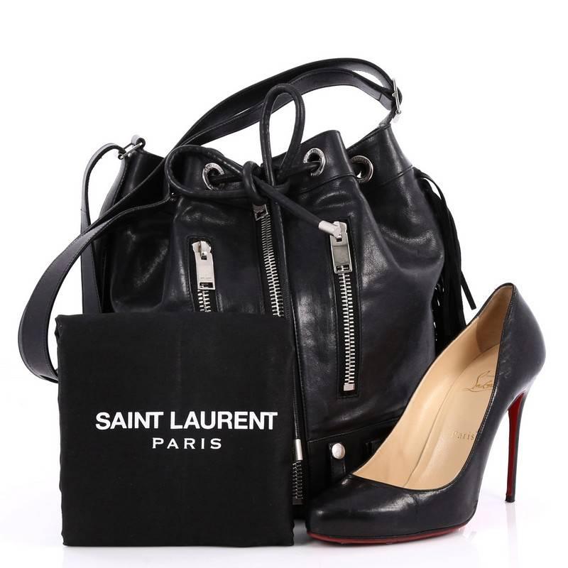 This authentic Saint Laurent Rider Bucket Bag Fringe Leather Large will remind us of the edgy details found on biker jackets. Crafted from black leather with leather fringe detailing on the sides, this edgy bucket bag features an adjustable shoulder